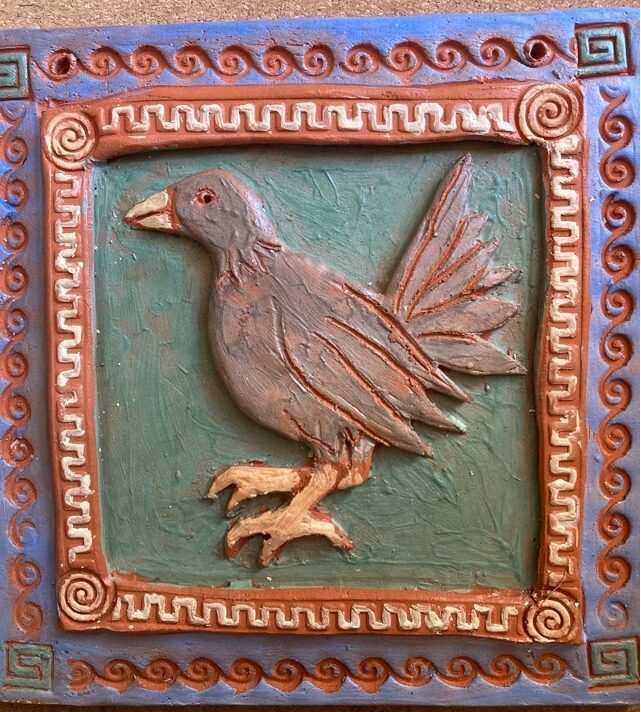 viereckige Kachel aus Keramik mit einem Relief, das einen Vogel darstellt.